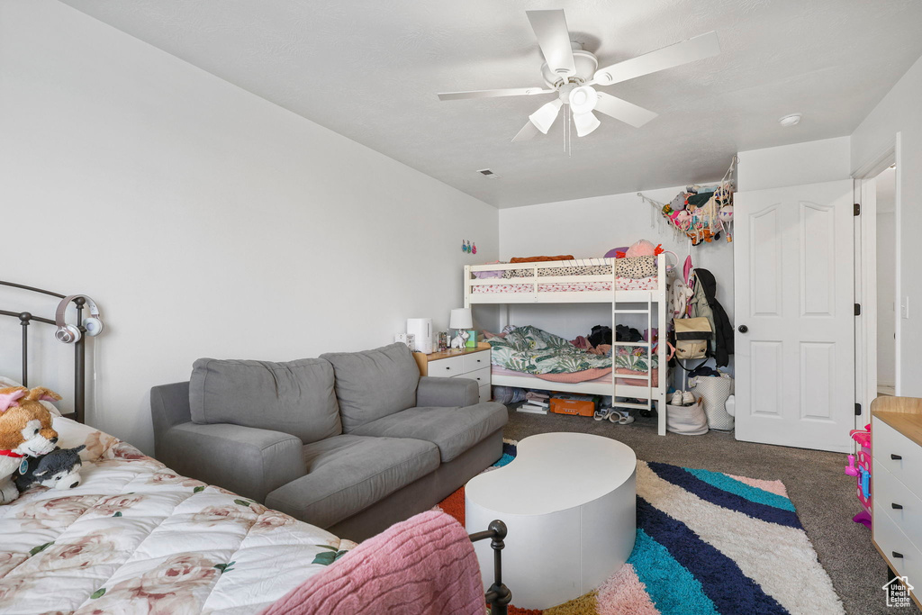 Carpeted bedroom featuring ceiling fan