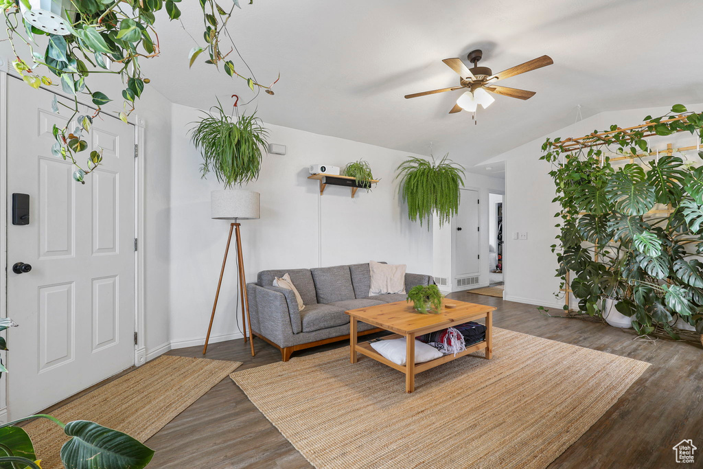 Living area featuring baseboards, visible vents, a ceiling fan, wood finished floors, and vaulted ceiling