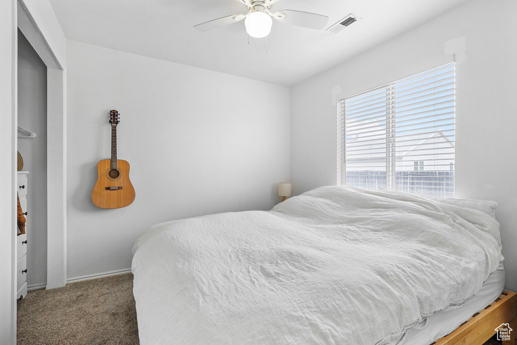 Bedroom with carpet, visible vents, and a ceiling fan