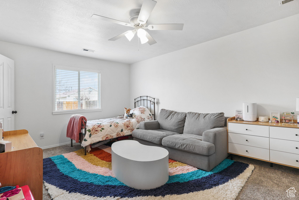 Carpeted bedroom with ceiling fan and visible vents