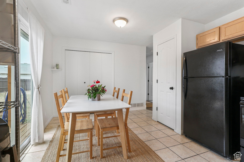 Dining space featuring light tile patterned floors, visible vents, and baseboards