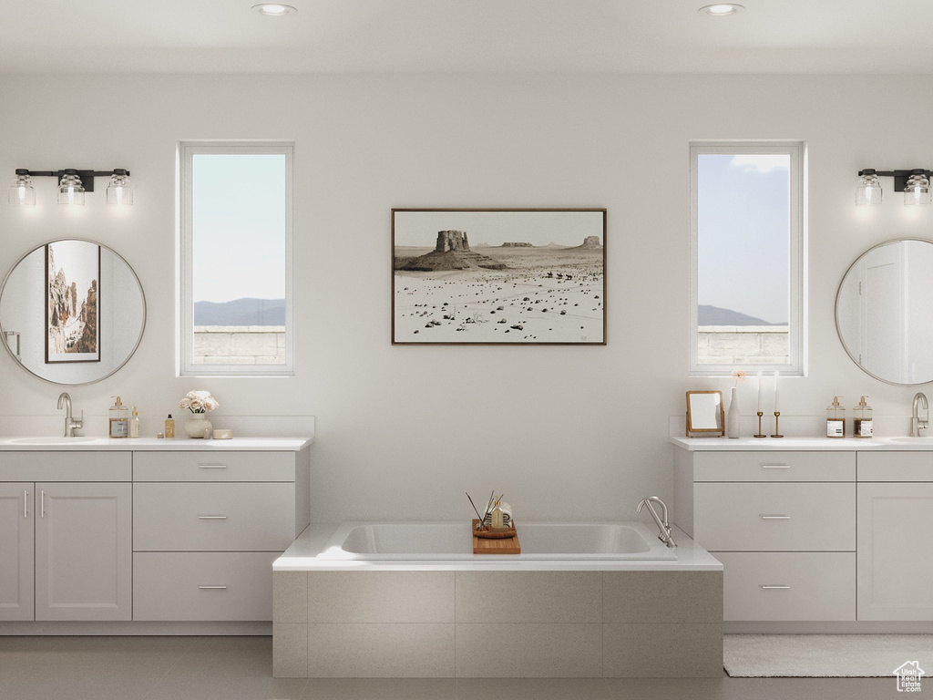 Bathroom featuring a garden tub, two vanities, a sink, and recessed lighting