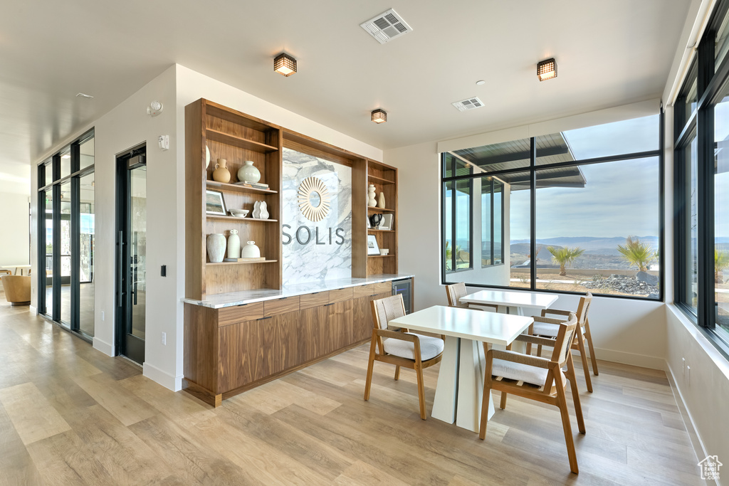 Dining room featuring light wood finished floors, visible vents, and a mountain view