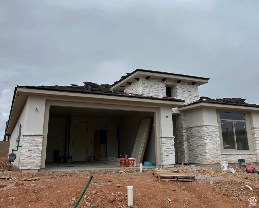 Prairie-style home with stone siding and stucco siding