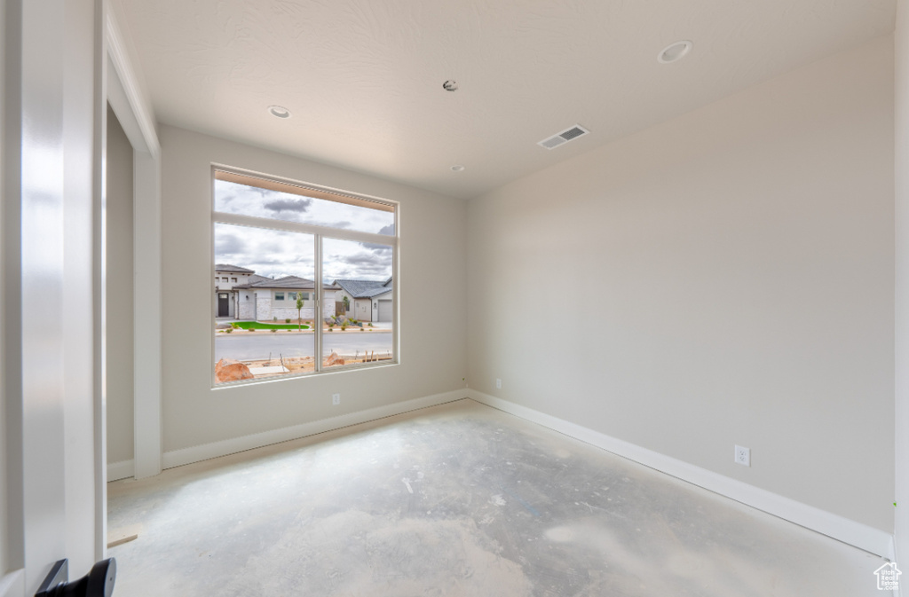 Unfurnished room with unfinished concrete flooring, baseboards, and recessed lighting