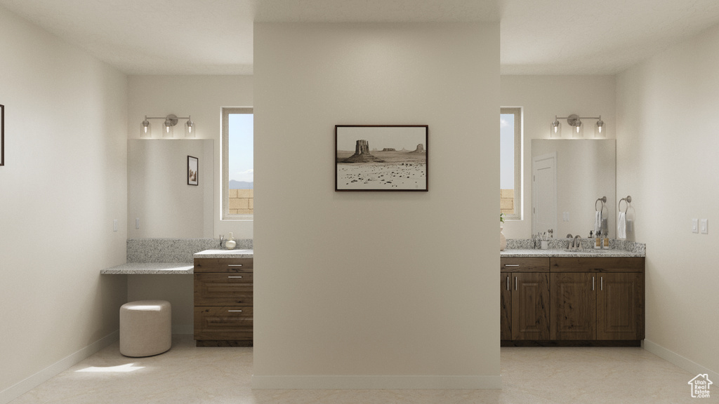 Full bathroom with two vanities, a sink, and baseboards