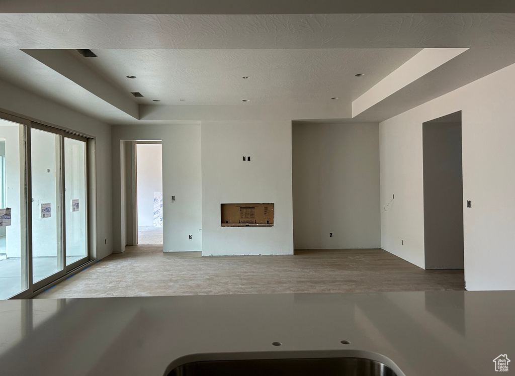 Unfurnished living room with a tray ceiling