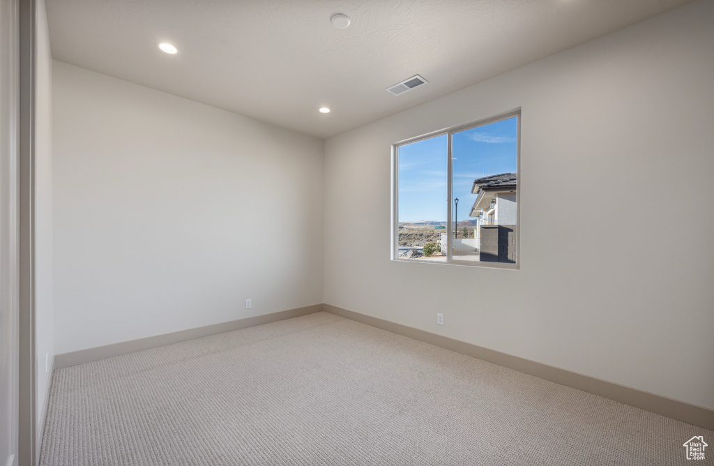 Spare room featuring carpet, visible vents, baseboards, and recessed lighting