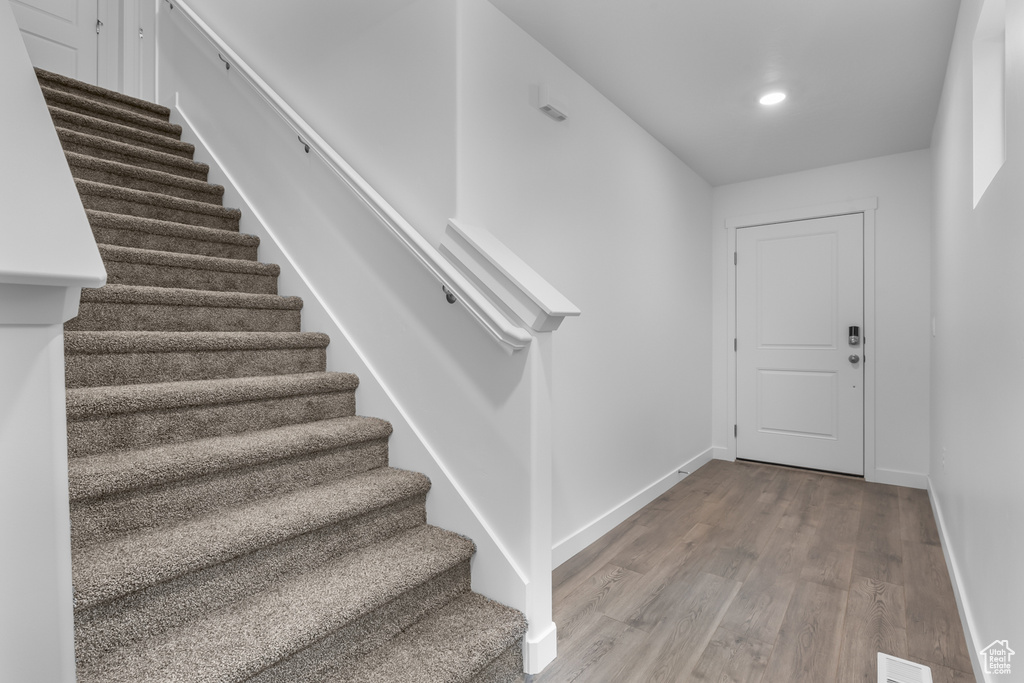 Foyer featuring recessed lighting, visible vents, stairway, wood finished floors, and baseboards