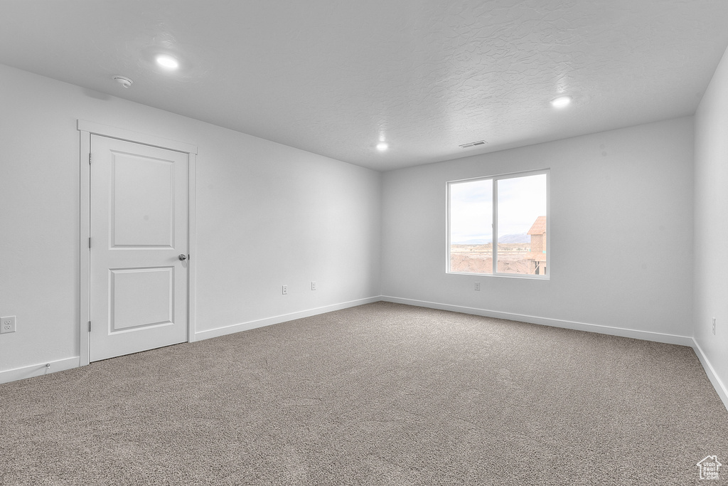 Unfurnished room featuring baseboards, visible vents, a textured ceiling, carpet flooring, and recessed lighting