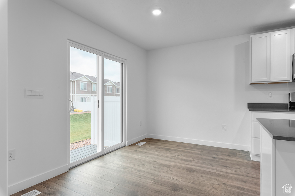 Unfurnished dining area featuring light wood finished floors, recessed lighting, and baseboards
