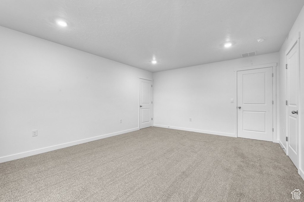 Spare room with carpet floors, recessed lighting, visible vents, and baseboards