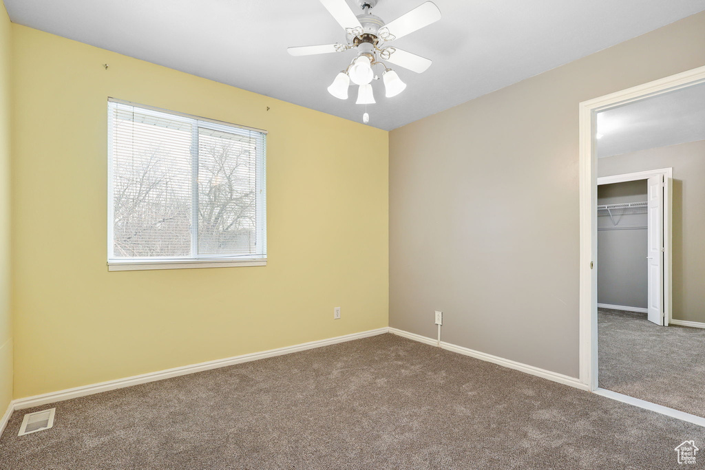 Unfurnished bedroom featuring a closet, carpet flooring, a ceiling fan, and baseboards