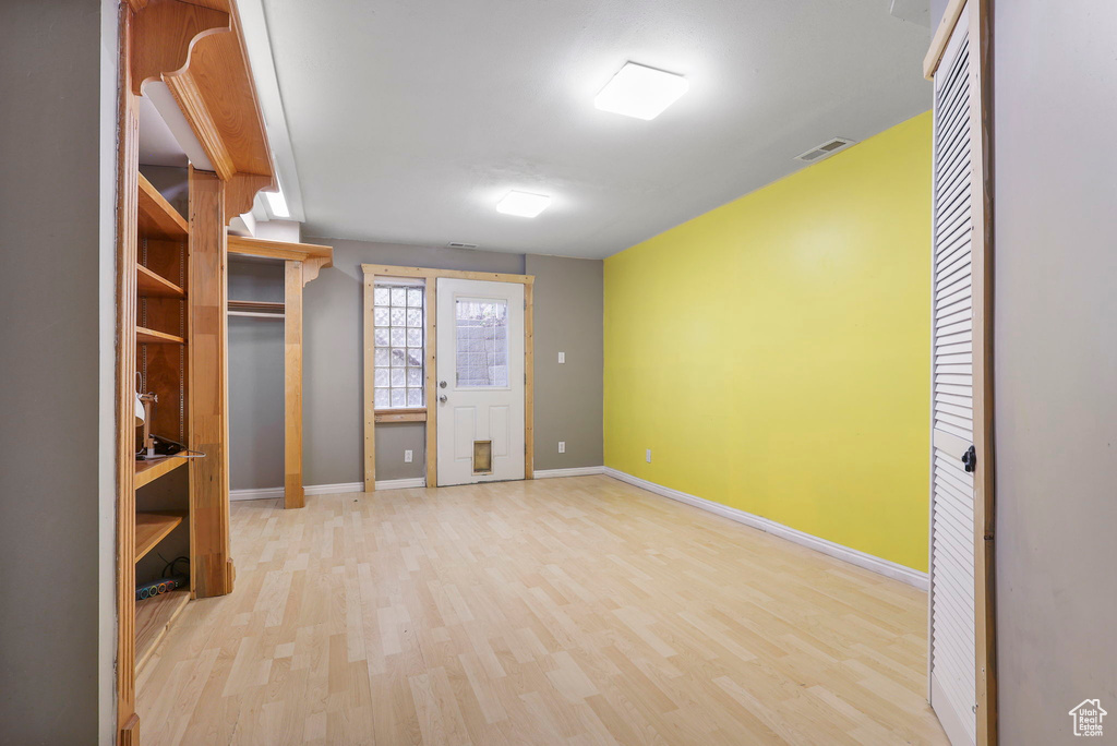 Spare room with baseboards, visible vents, and wood finished floors