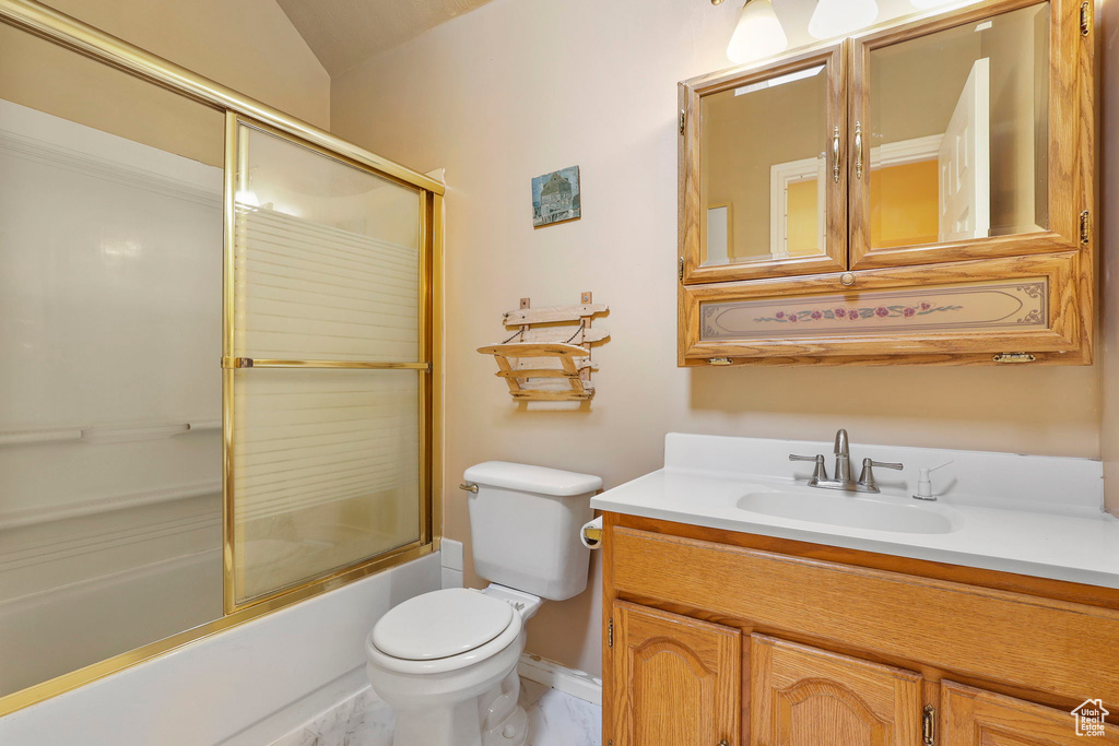 Bathroom featuring enclosed tub / shower combo, vanity, and toilet