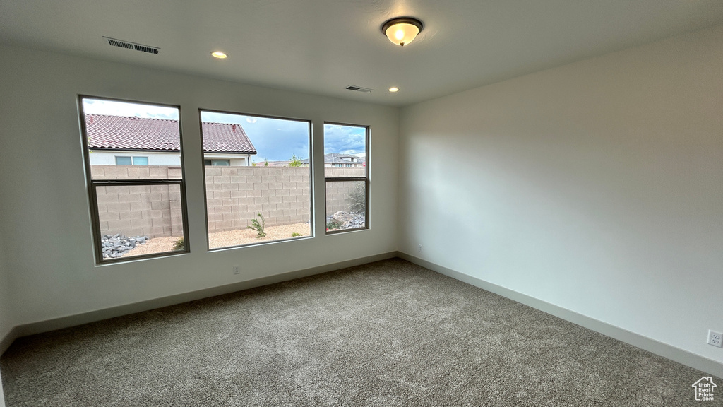 Carpeted empty room featuring recessed lighting, baseboards, and visible vents