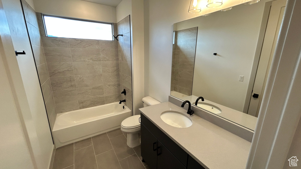 Bathroom with toilet, shower / bath combination, tile patterned flooring, and vanity