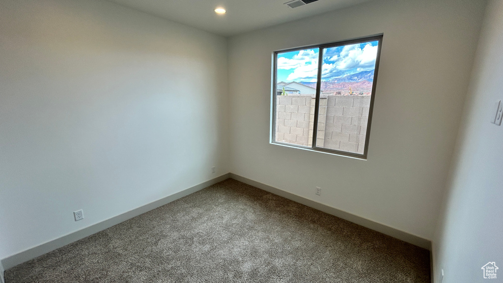 Carpeted empty room featuring recessed lighting and baseboards