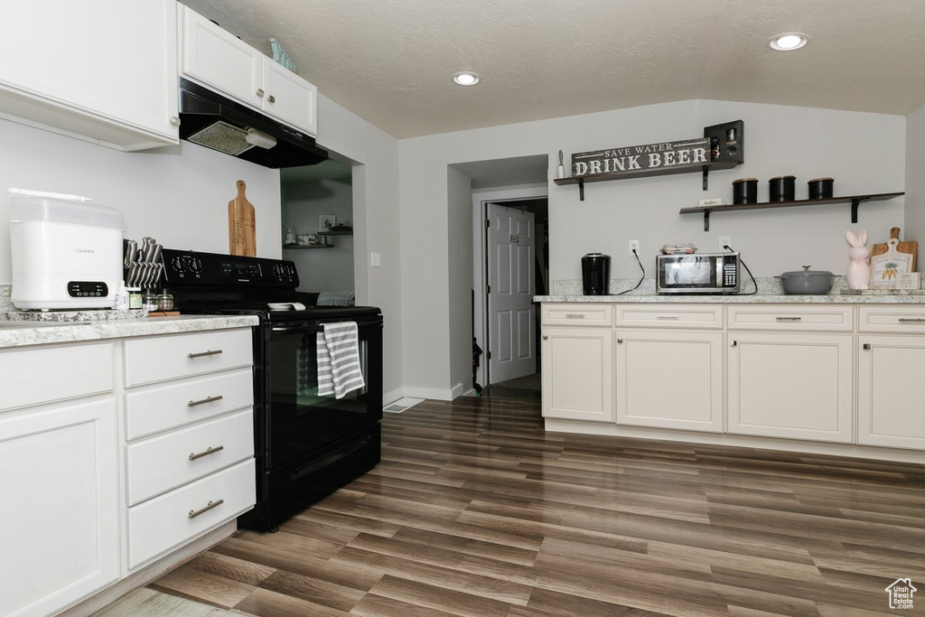 Kitchen featuring stainless steel microwave, dark wood-type flooring, white cabinetry, under cabinet range hood, and black / electric stove