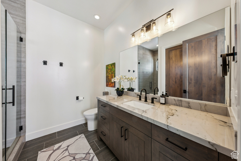 Bathroom featuring vanity, a shower stall, wood tiled floors, and recessed lighting