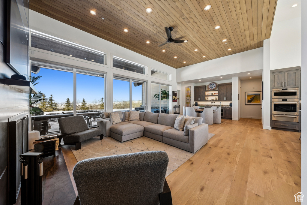 Living area featuring wood ceiling, recessed lighting, a high ceiling, a ceiling fan, and light wood-type flooring