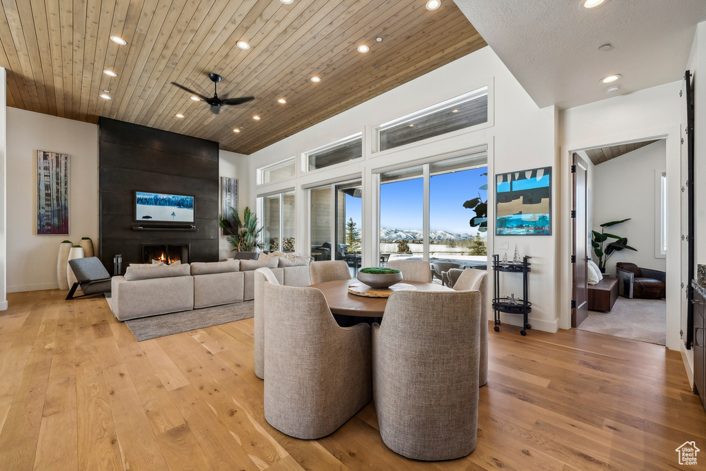Dining space with recessed lighting, light wood-style floors, a fireplace, ceiling fan, and wood ceiling