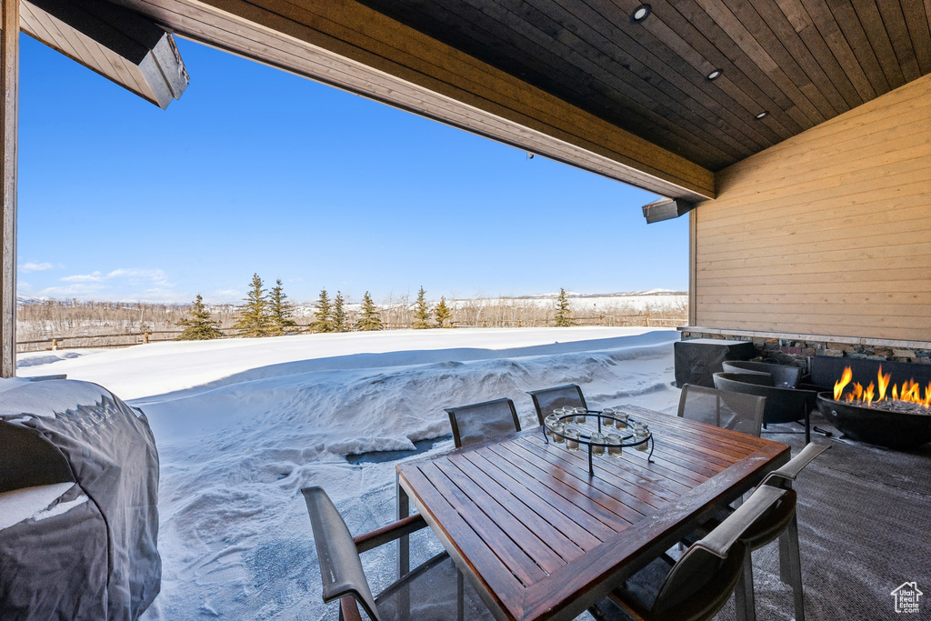 Snow covered patio featuring an outdoor fire pit and a patio area