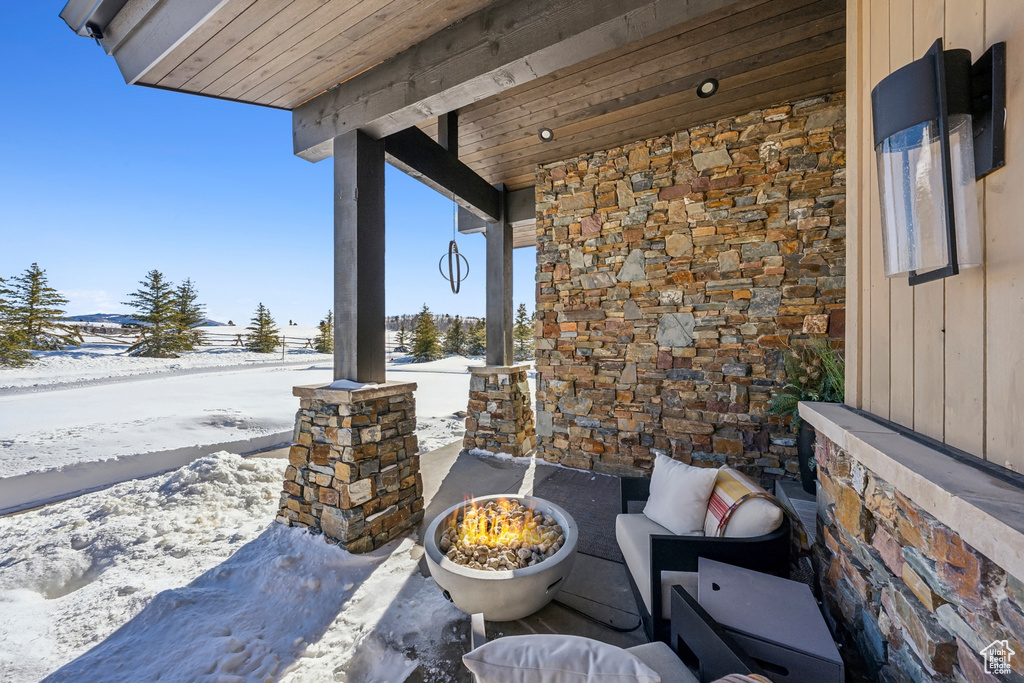 Snow covered patio featuring a porch