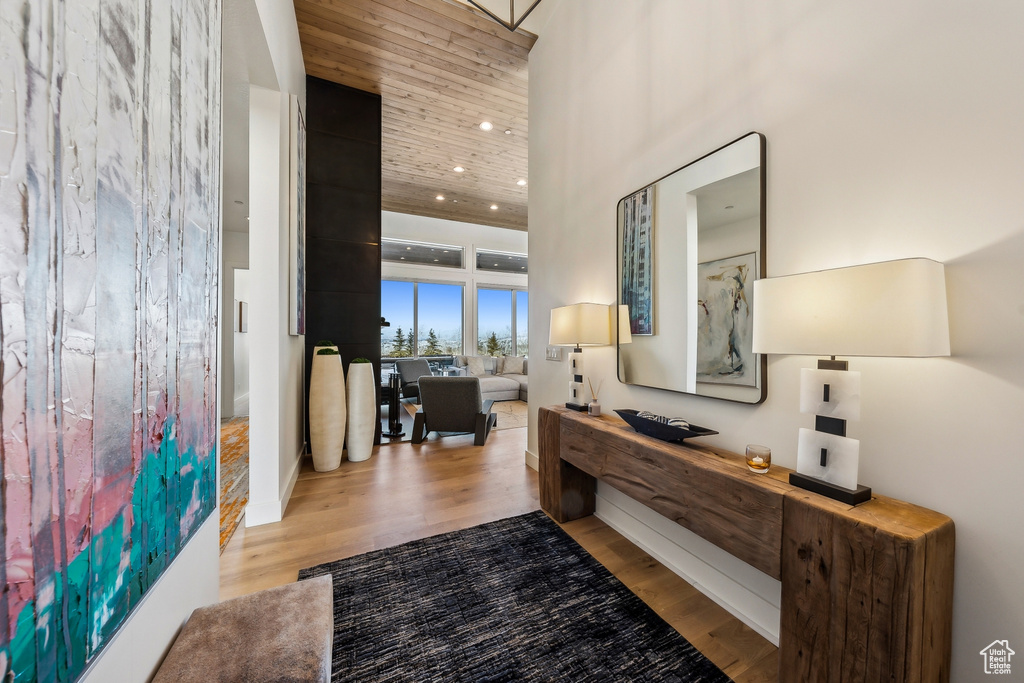 Hallway featuring wood finished floors, a high ceiling, and recessed lighting
