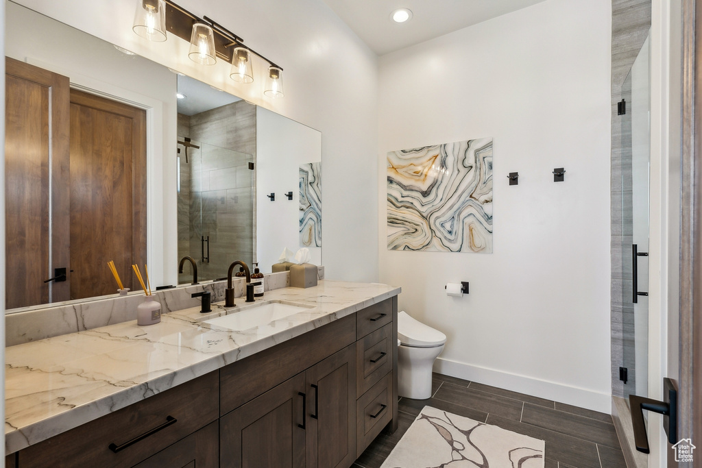 Bathroom featuring vanity, a shower stall, and wood tiled floors