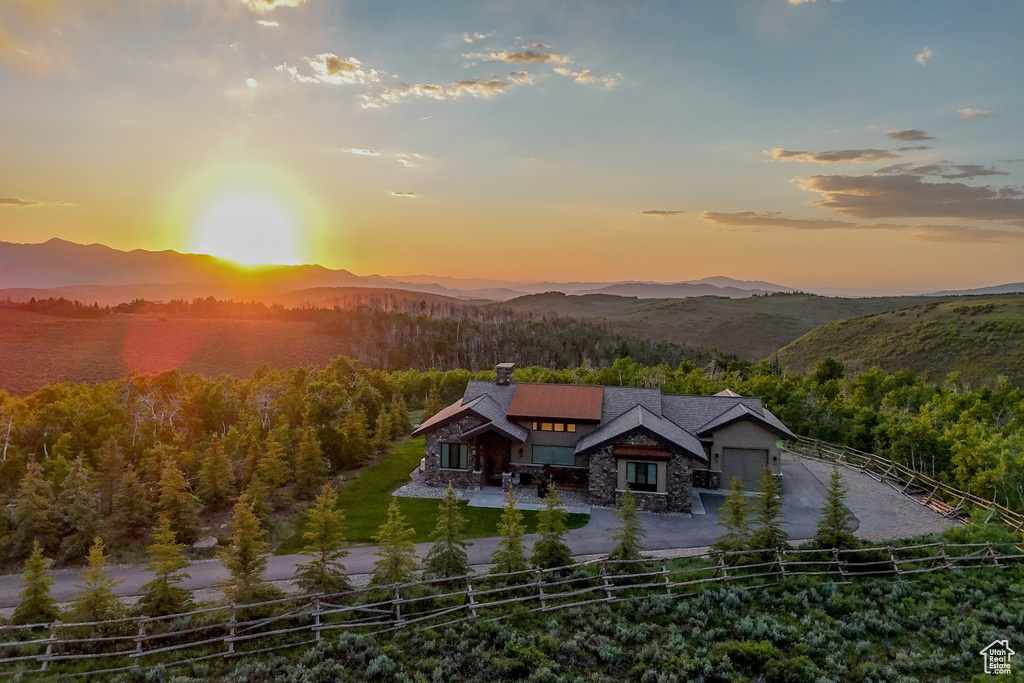 View from above of property featuring a mountain backdrop and a heavily wooded area