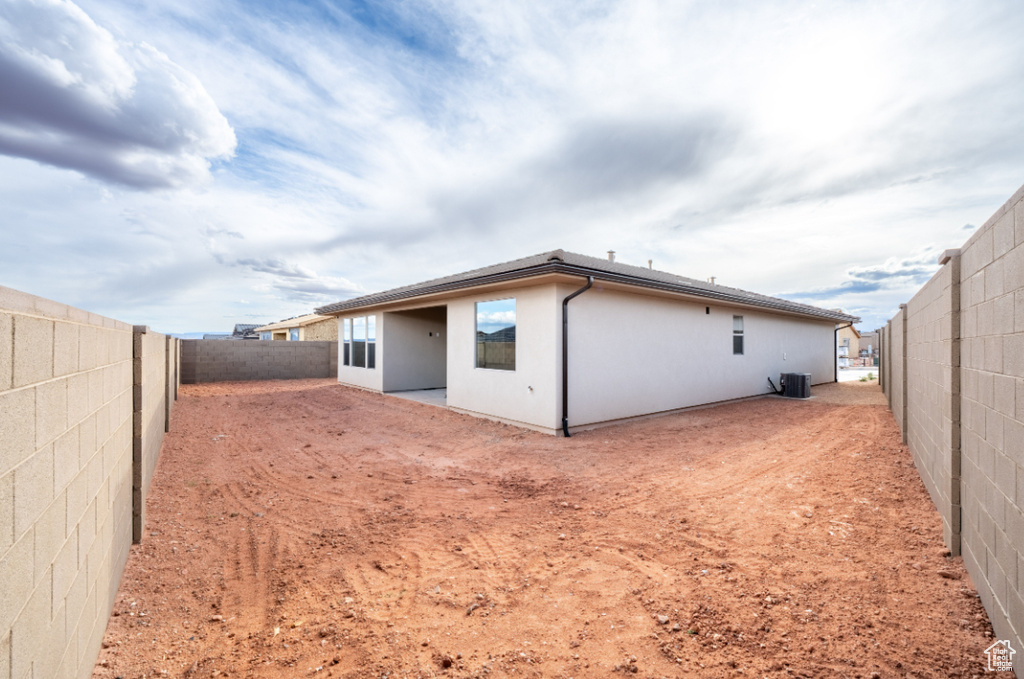 Back of property featuring a fenced backyard, stucco siding, and cooling unit