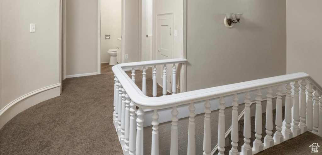 Hall featuring carpet flooring and an upstairs landing