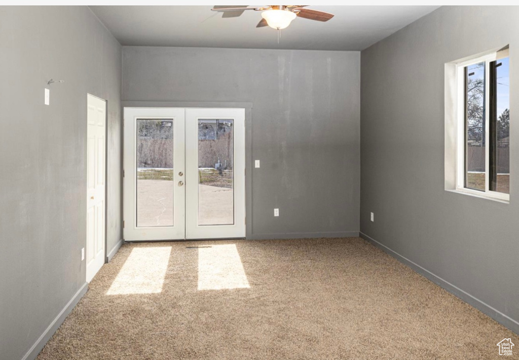 Spare room featuring carpet floors, french doors, baseboards, and a ceiling fan