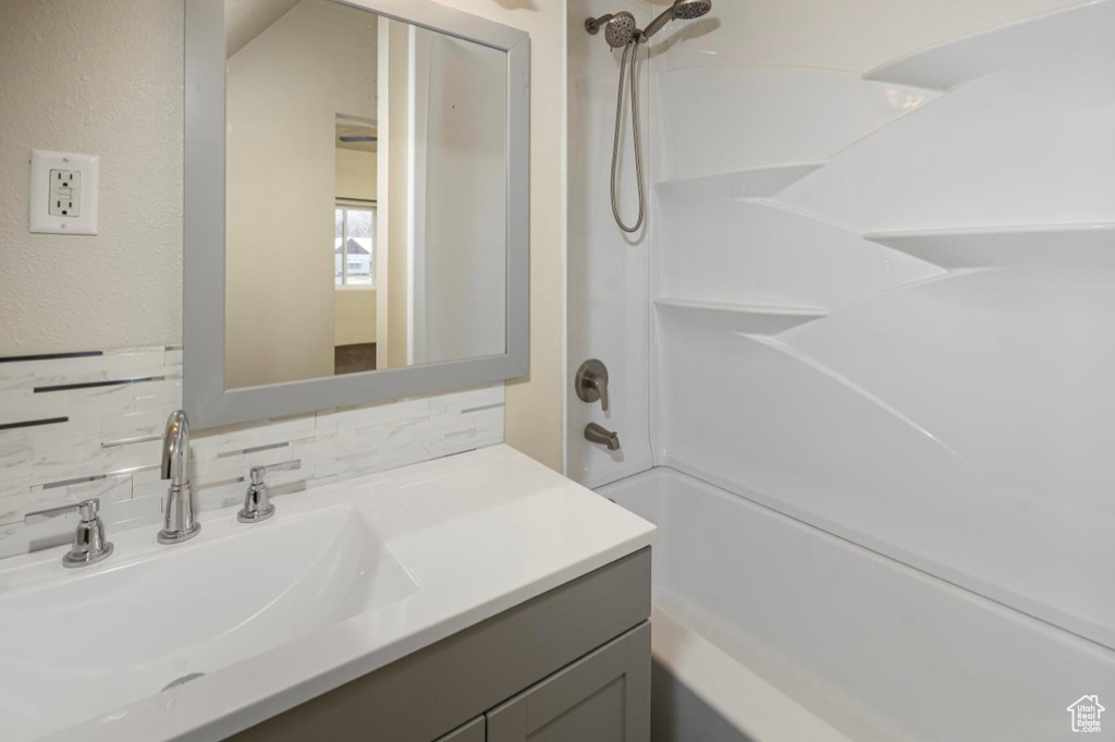 Bathroom featuring tasteful backsplash, bathtub / shower combination, and vanity