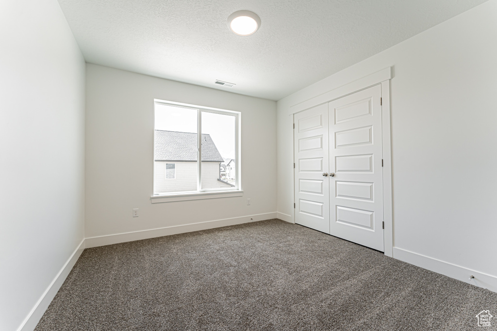 Unfurnished bedroom featuring carpet floors and a closet