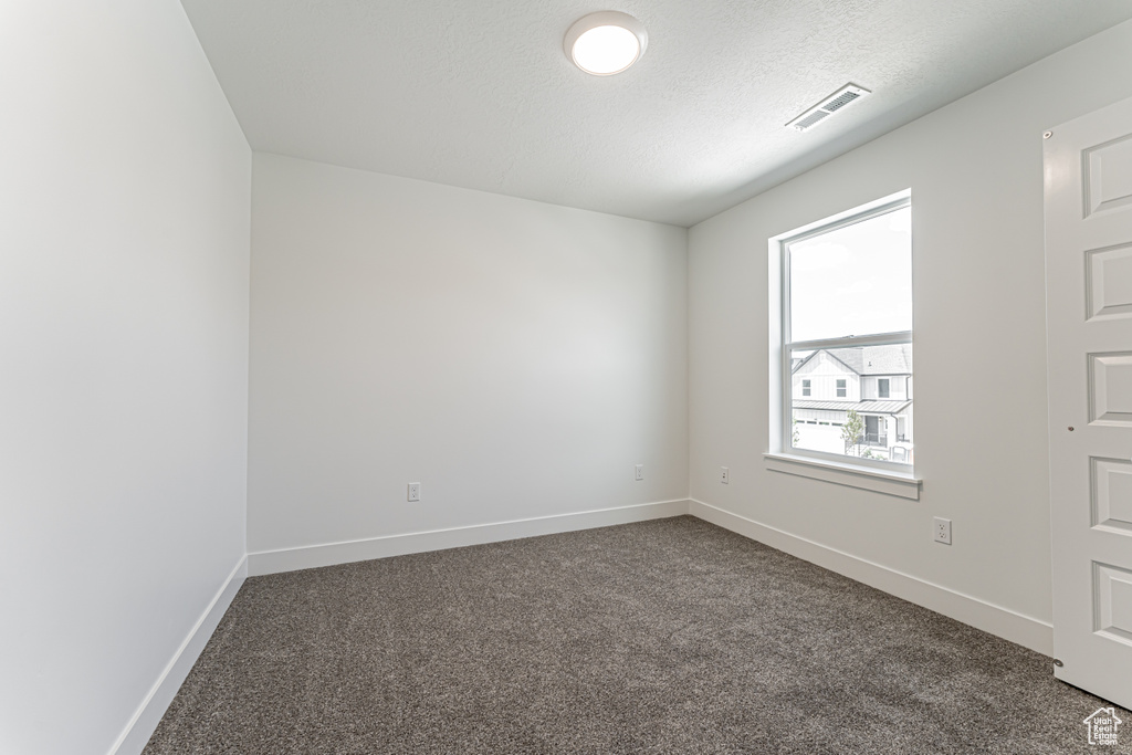 Spare room with dark carpet