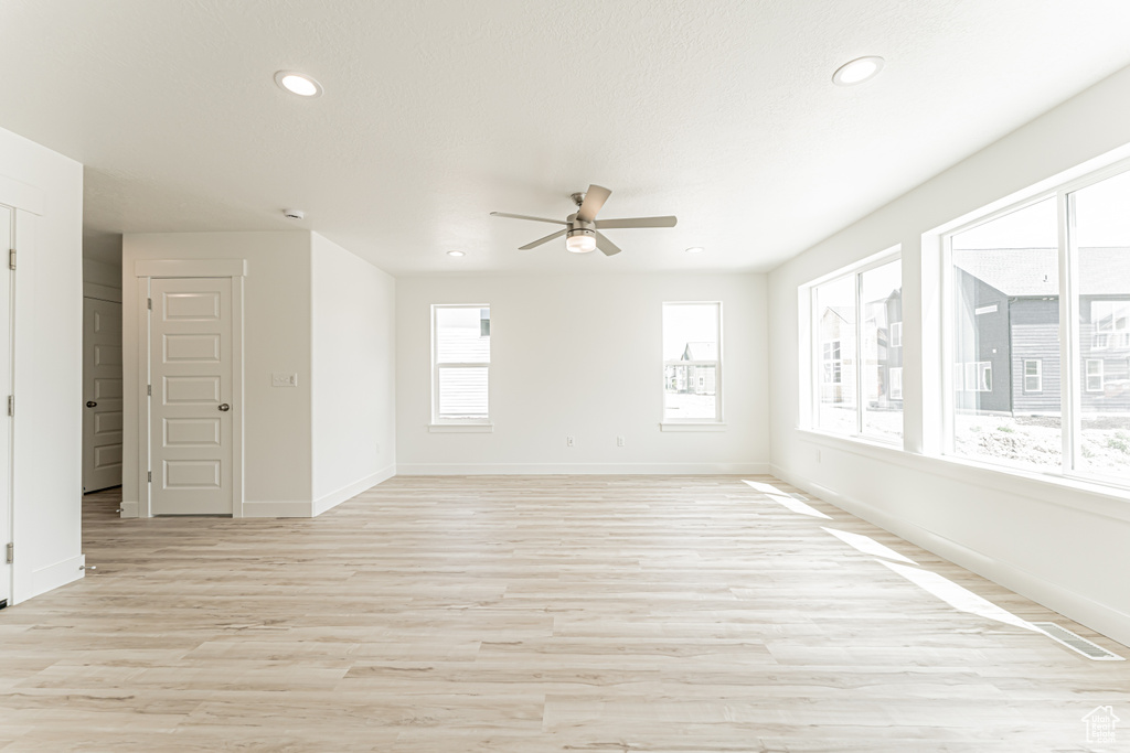 Empty room featuring ceiling fan, light wood-type flooring, and recessed lighting