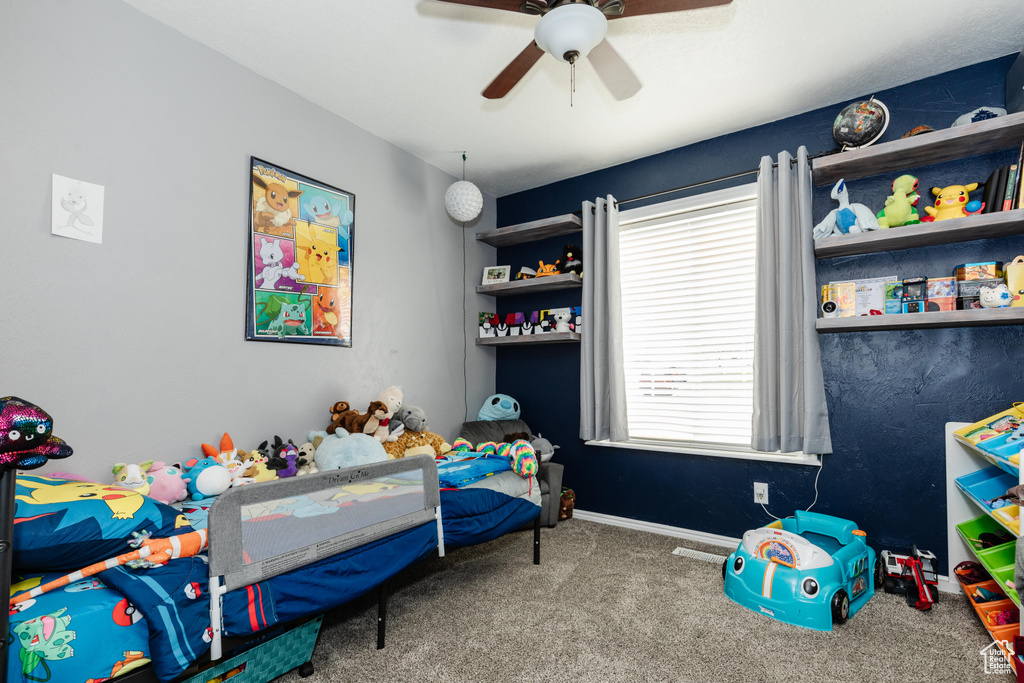 Bedroom with ceiling fan, carpet floors, and baseboards