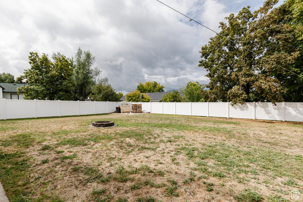 View of yard featuring an outdoor fire pit and a fenced backyard