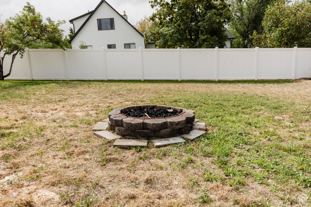 View of yard featuring fence and a fire pit