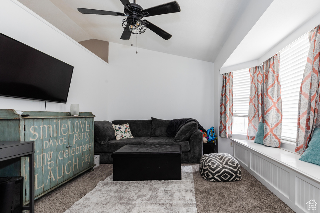 Living area with lofted ceiling, ceiling fan, and carpet