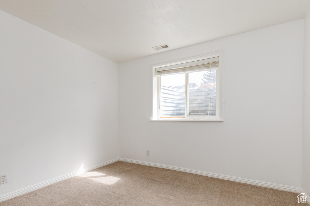 Unfurnished room featuring light carpet, baseboards, and visible vents