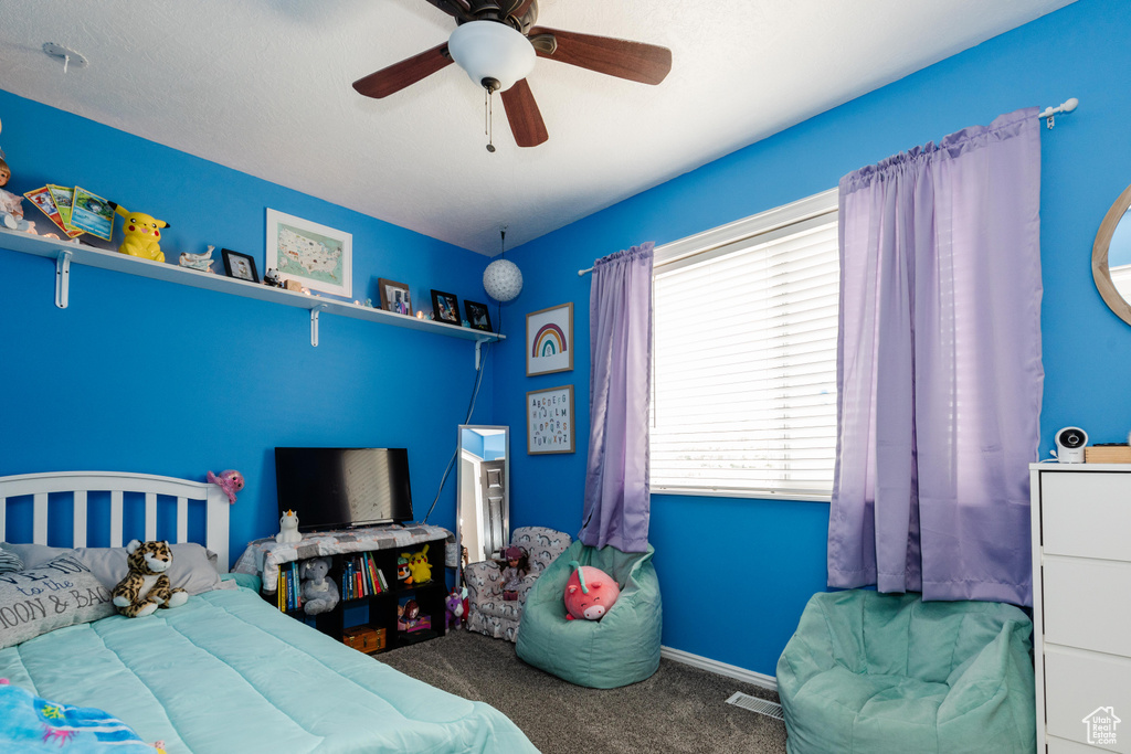 Bedroom featuring carpet flooring, ceiling fan, and visible vents