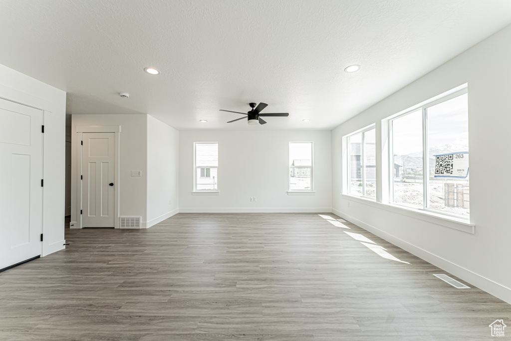 Empty room with a ceiling fan, recessed lighting, light wood-type flooring, and a smoke detector