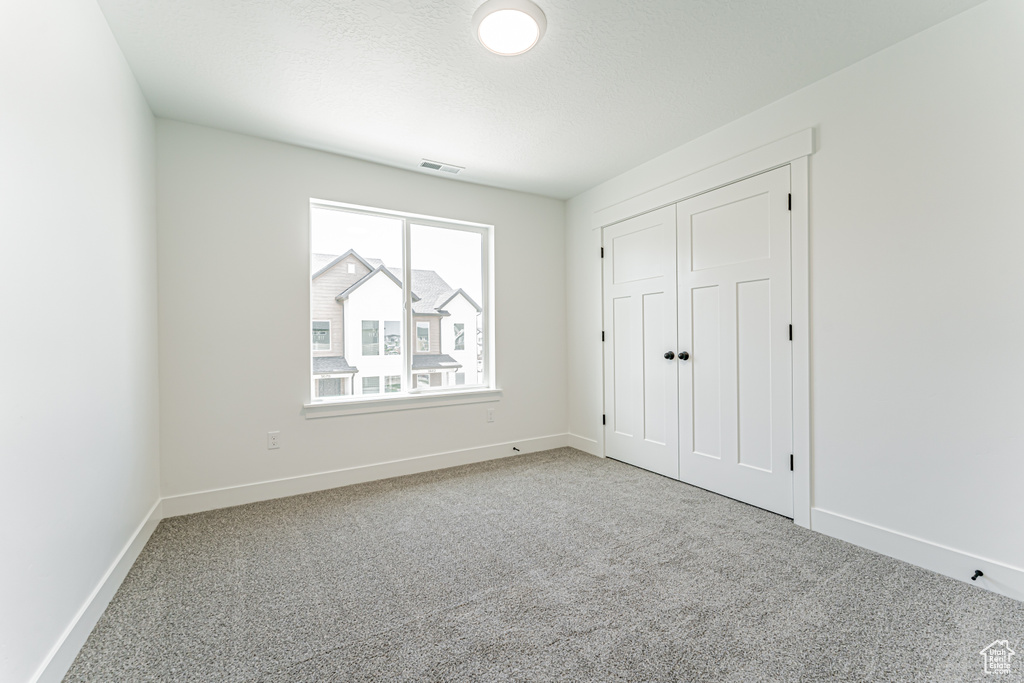 Unfurnished bedroom with carpet and a closet