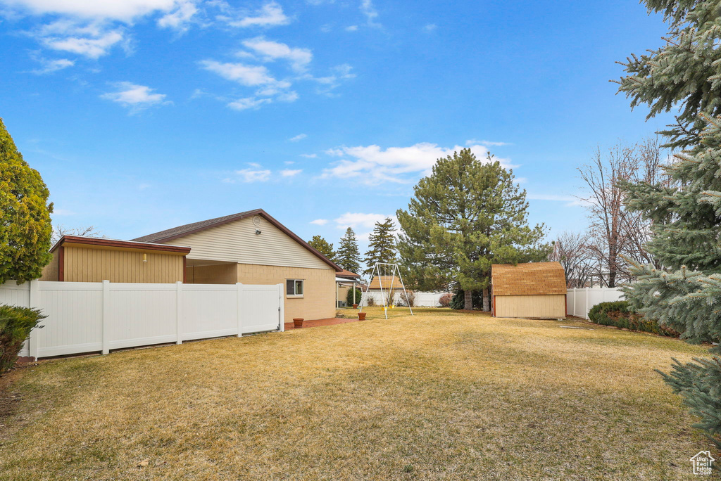 View of yard with a storage unit, an outdoor structure, and a fenced backyard