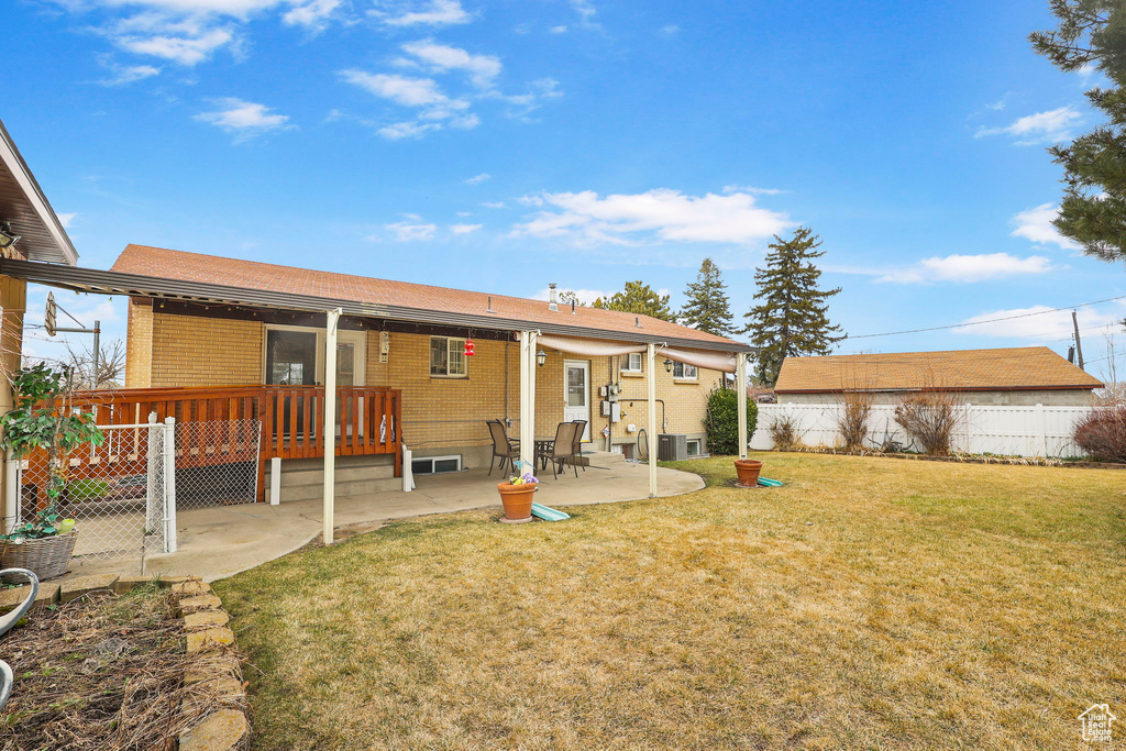 Back of property featuring a yard, brick siding, a patio, and fence