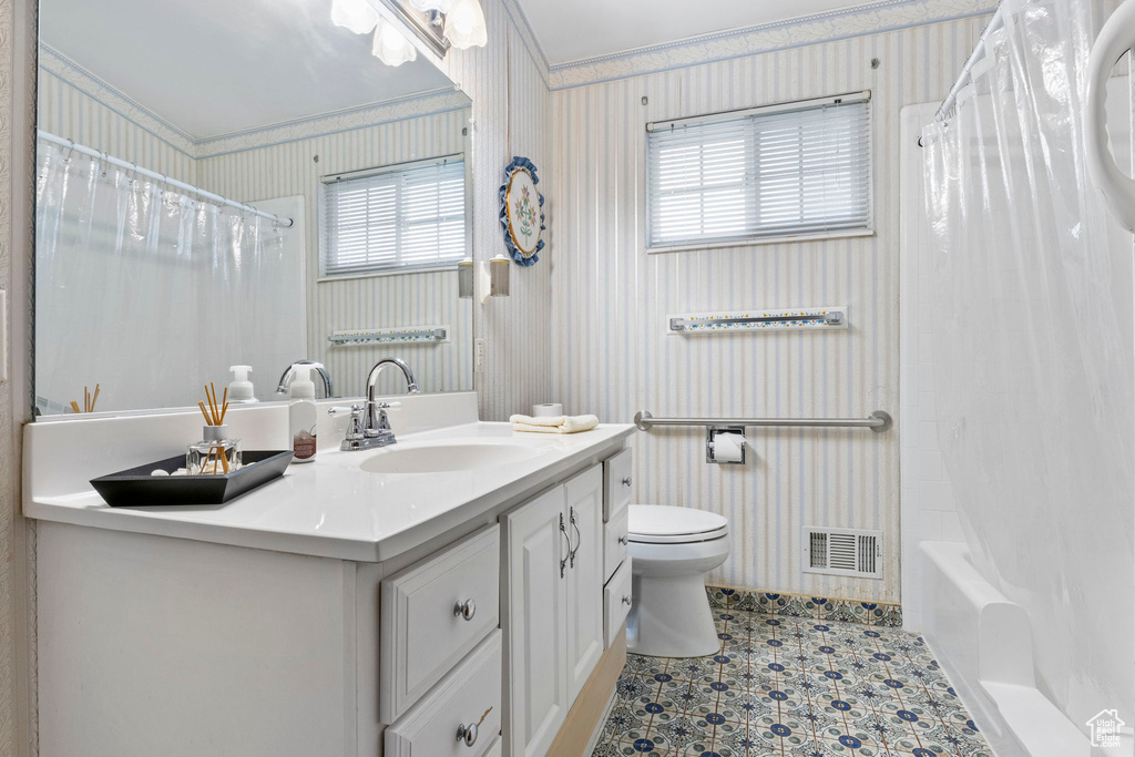 Bathroom featuring toilet, wallpapered walls, visible vents, and vanity