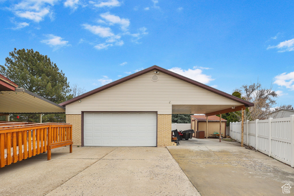 Exterior space featuring a garage, fence, and a shed